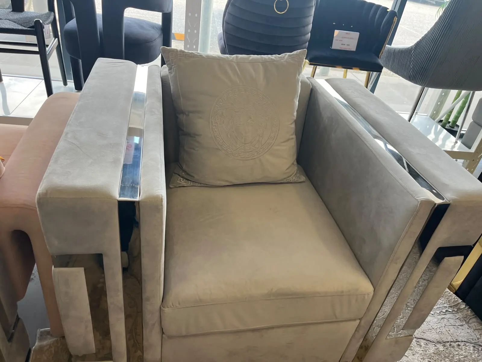 Amara single seater grey velvet armchair with silver frame and decorative cushion