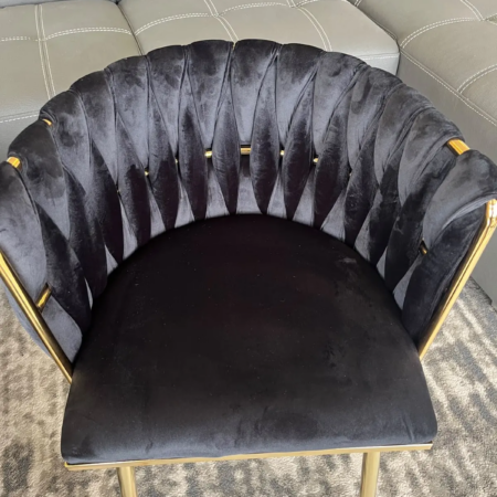 Black velvet dining chair with scalloped petal backrest and gold frame accents